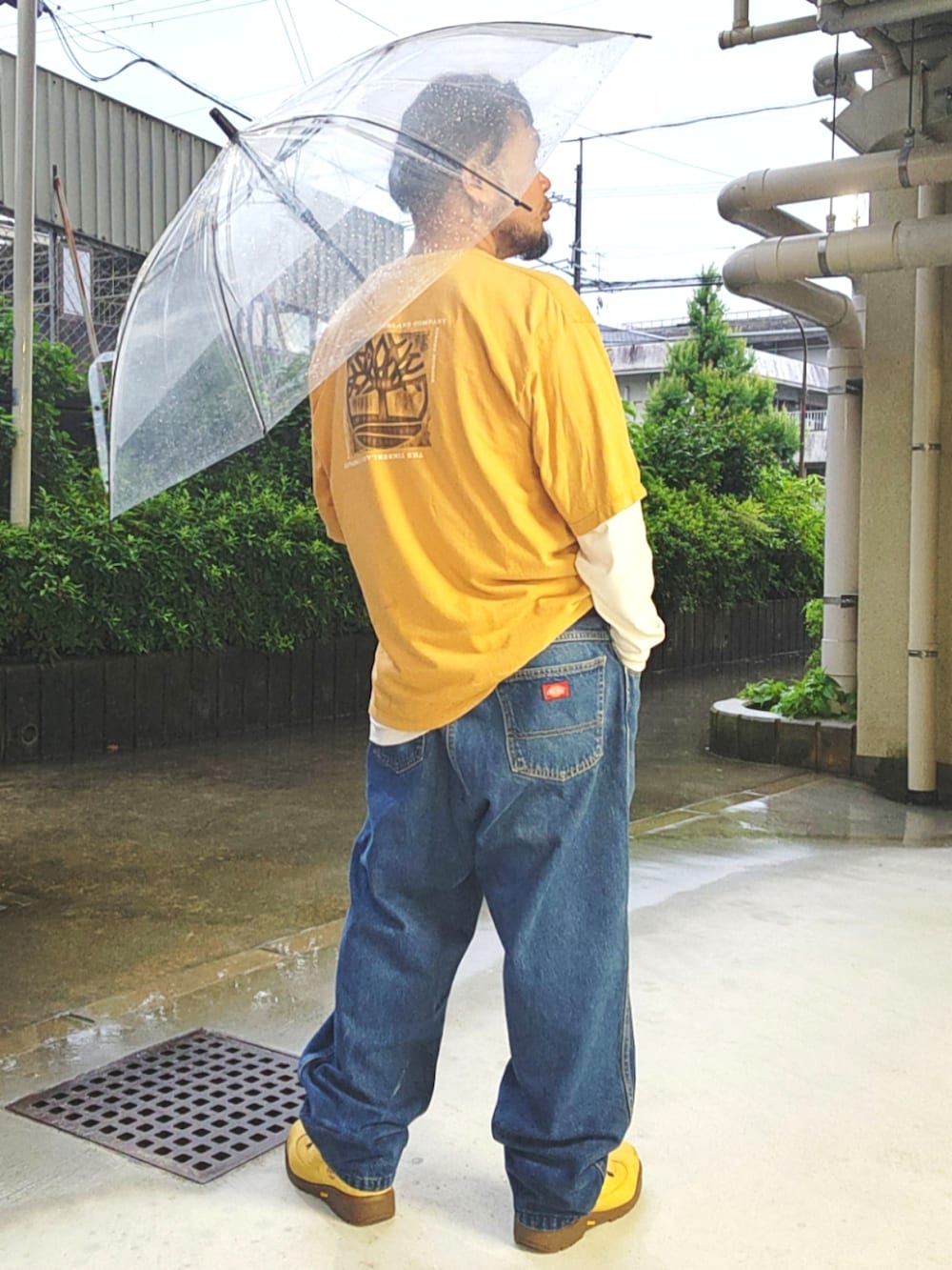 ゴールド系のブーツ、ブルー系のデニムパンツ、イエロー系のTシャツ/カットソーを着用したメンズの夏コーディネートの2枚目の写真