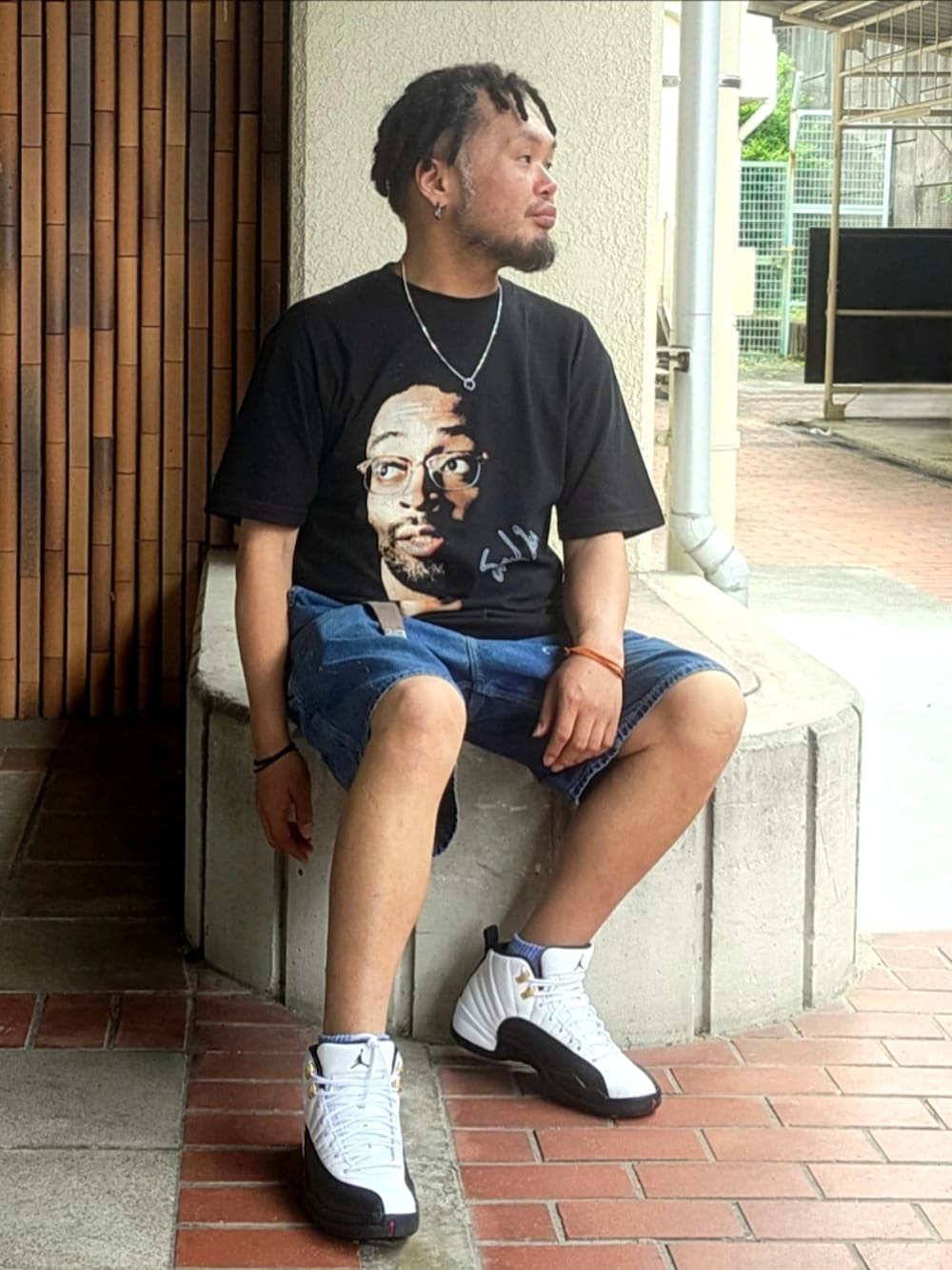 ホワイト系のスニーカー、ブルー系のデニムパンツ、ブラック系のTシャツ/カットソーを着用したメンズの夏コーディネートの5枚目の写真