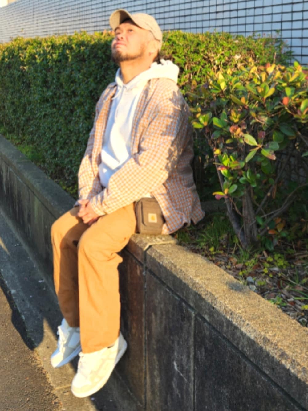 ホワイト系のスニーカー、ブラウン系のカーゴパンツ、グレー系のパーカーを着用したメンズの春コーディネートの2枚目の写真