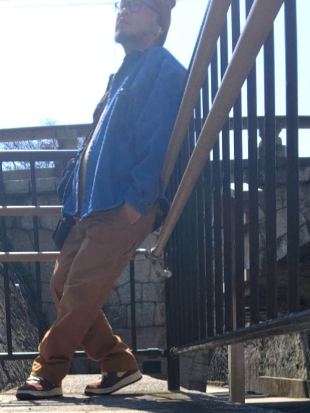 ブラウン系のスニーカー、ブラウン系のカーゴパンツ、ブルー系のショルダーバッグを着用したメンズの春コーディネートの3枚目の写真