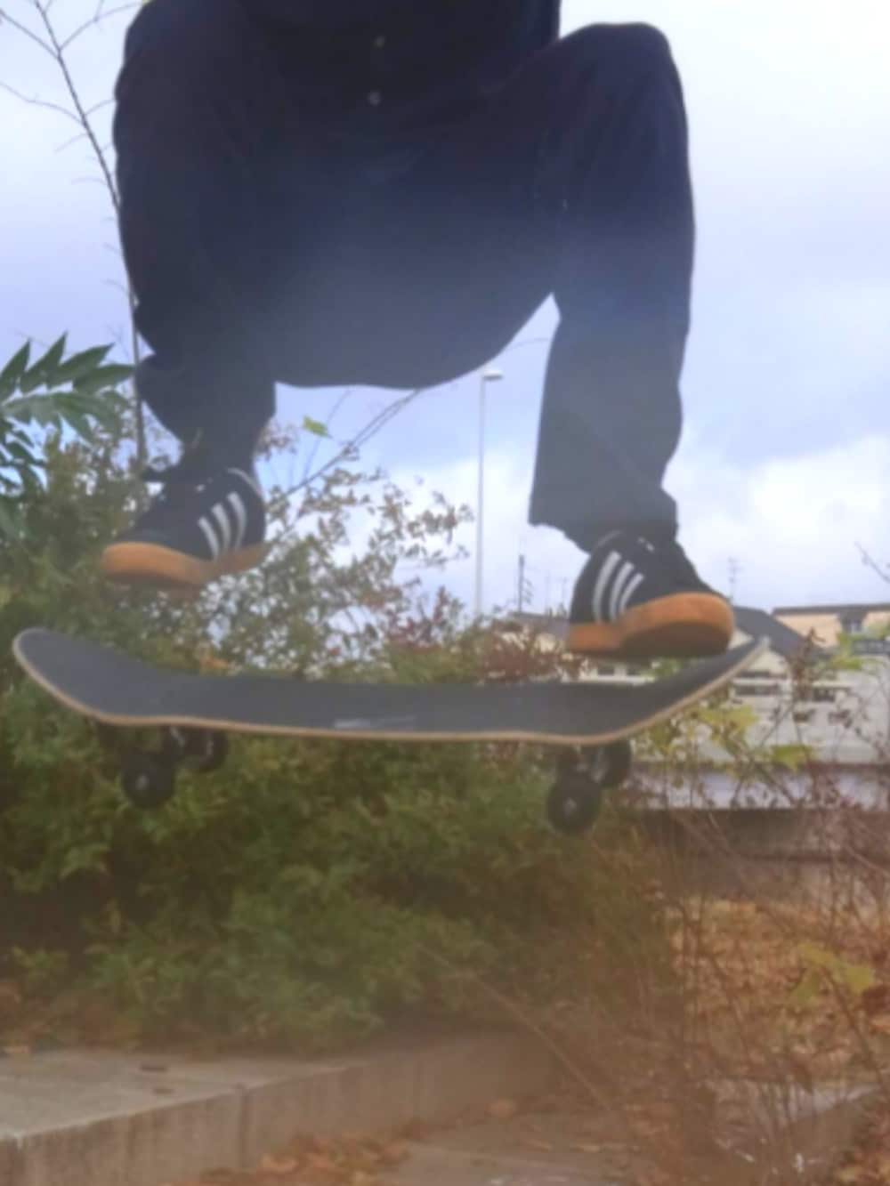 ブラック系のナイロンジャケット、ブルー系のデニムパンツ、ブルー系のスニーカーを着用したメンズの春コーディネートの5枚目の写真