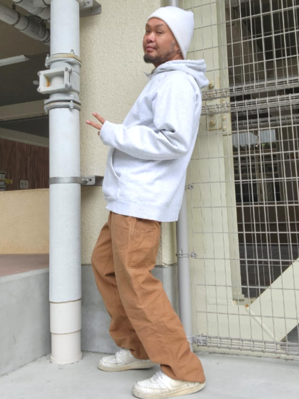 ホワイト系のスニーカー、ブラウン系のカーゴパンツ、グレー系のパーカーを着用したメンズの春コーディネートの2枚目の写真