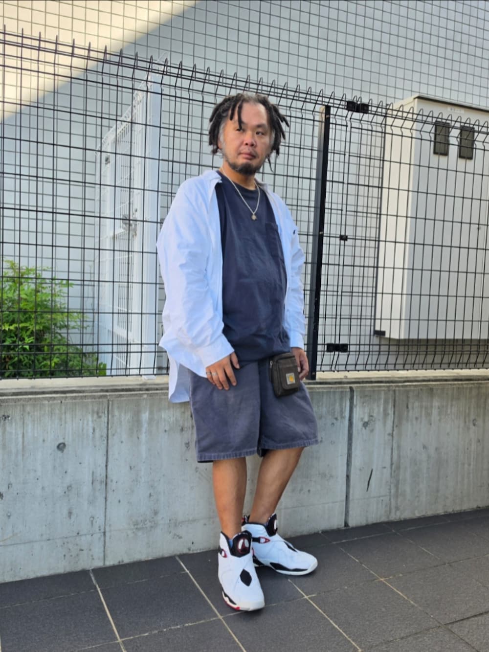 ホワイト系のスニーカー、ブルー系のカーゴパンツ、ブルー系のTシャツ/カットソーを着用したメンズの秋コーディネートの2枚目の写真