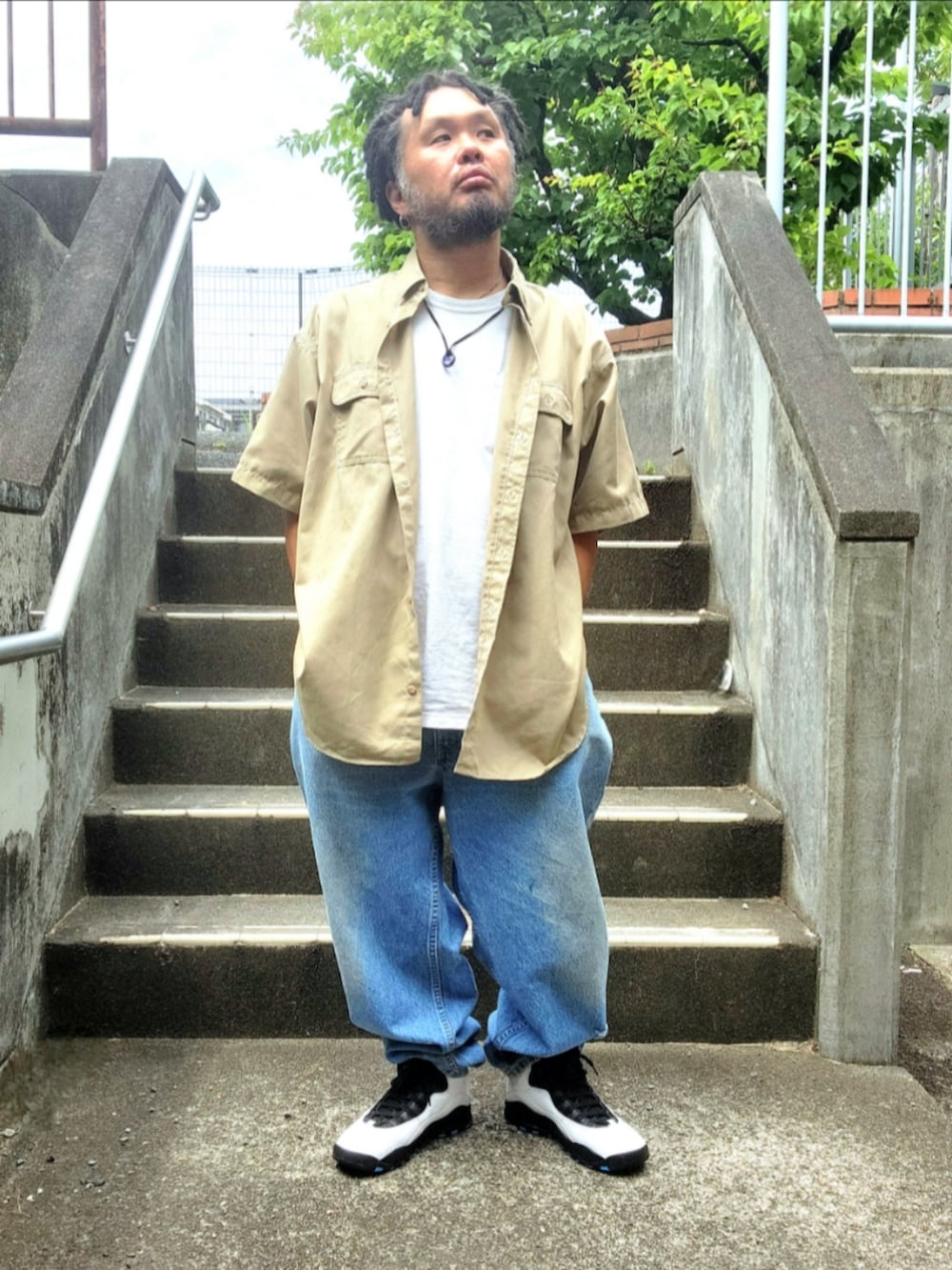 ブルー系のスニーカー、ブルー系のデニムパンツ、ホワイト系のTシャツ/カットソーを着用したメンズの夏コーディネートの4枚目の写真