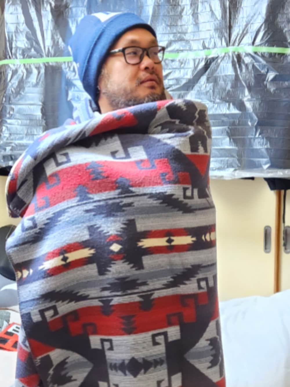 ブラウン系のミリタリージャケット、イエロー系のナイロンジャケット、ブラック系のパーカーを着用したメンズの春コーディネートの2枚目の写真