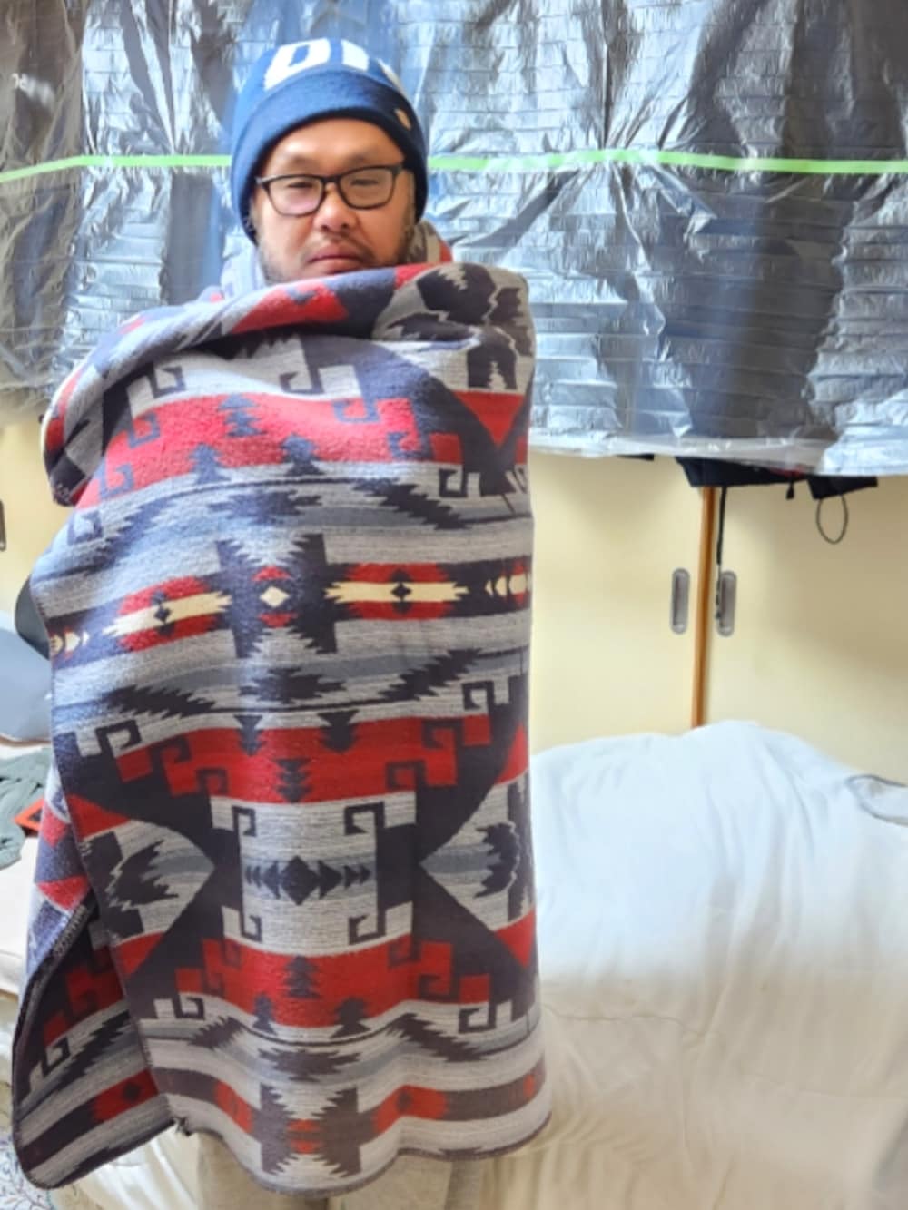 ブラウン系のミリタリージャケット、イエロー系のナイロンジャケット、ブラック系のパーカーを着用したメンズの春コーディネートの4枚目の写真