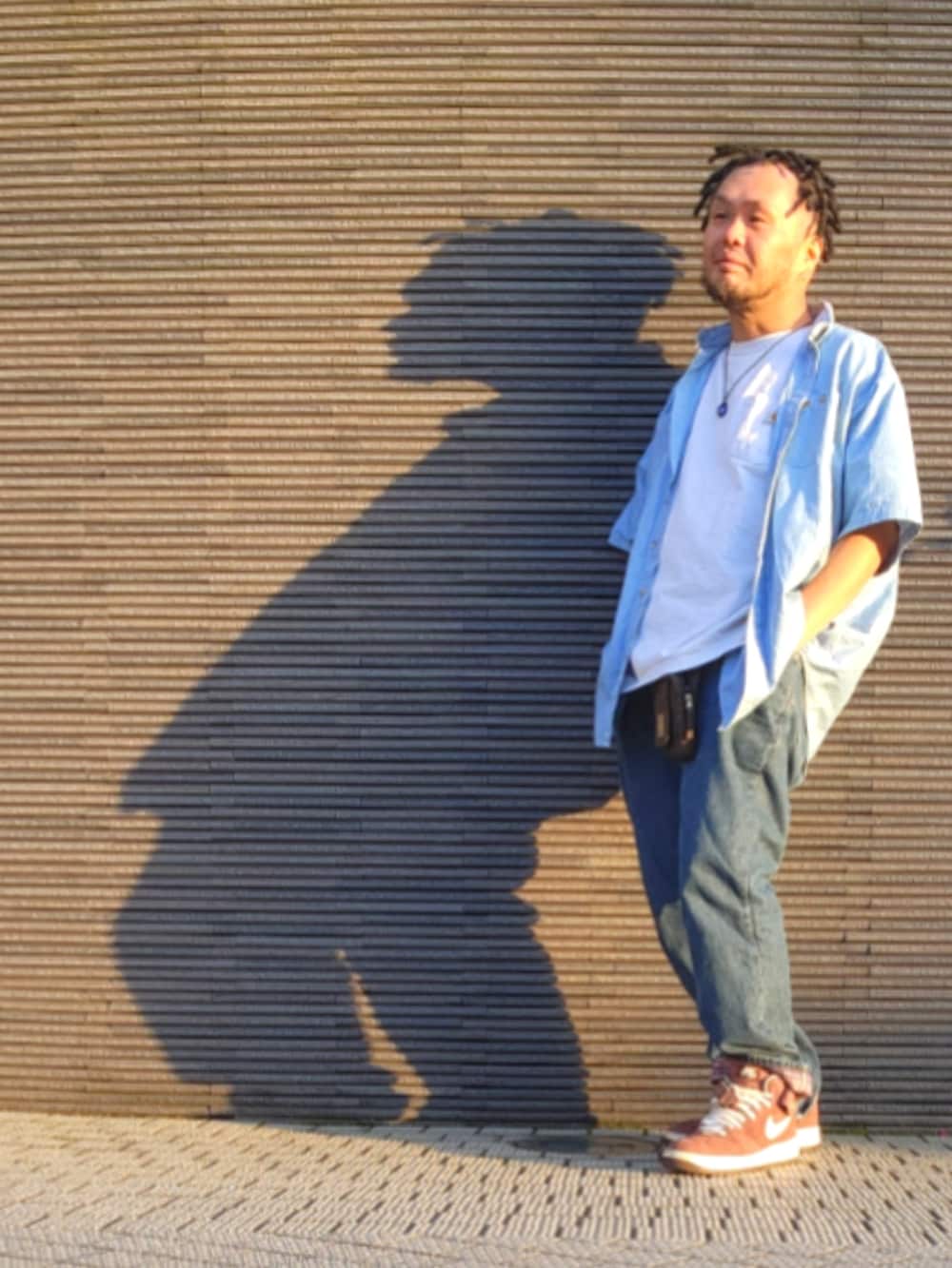 ブラウン系のスニーカー、ブルー系のデニムパンツ、ホワイト系のTシャツ/カットソーを着用したメンズの春コーディネートの4枚目の写真