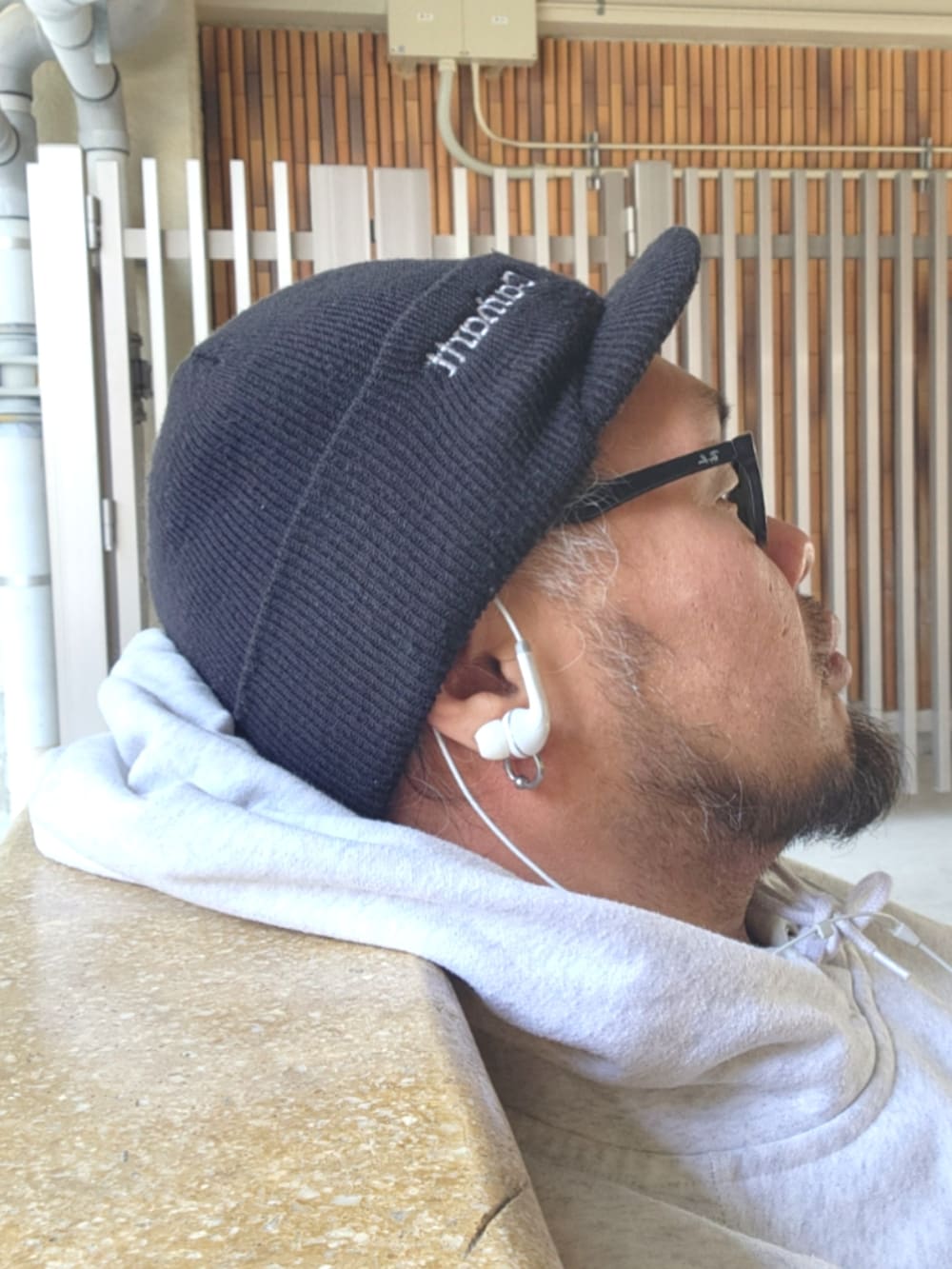 ホワイト系のスニーカー、ブラック系のチノパンツ、グレー系のパーカーを着用したメンズの春コーディネートの5枚目の写真