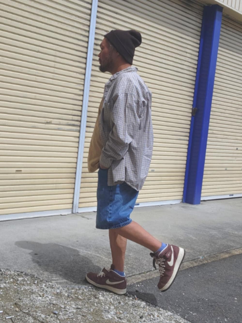 ブラウン系のスニーカー、ブルー系のデニムパンツ、ベージュ系のTシャツ/カットソーを着用したメンズの春コーディネートの4枚目の写真