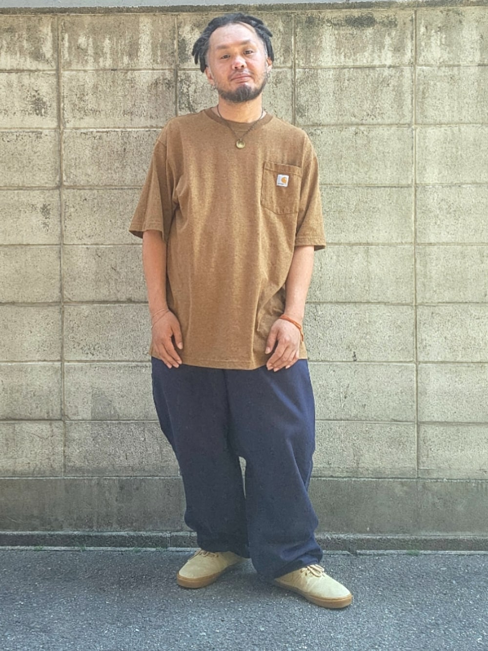 ブルー系のパンツ、ベージュ系のスニーカー、ブラウン系のTシャツ/カットソーを着用したメンズの春コーディネートの5枚目の写真