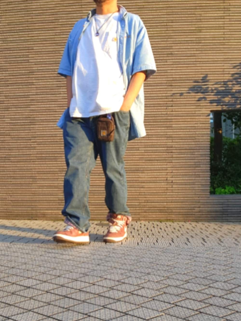 ブラウン系のスニーカー、ブルー系のデニムパンツ、ホワイト系のTシャツ/カットソーを着用したメンズの春コーディネートの5枚目の写真