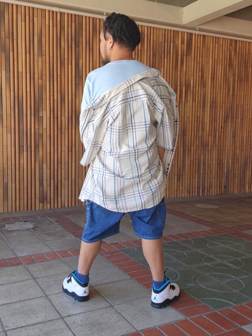 ホワイト系のスニーカー、ブルー系のデニムパンツ、ブルー系のTシャツ/カットソーを着用したメンズの夏コーディネートの3枚目の写真