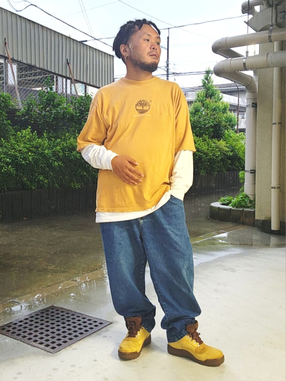 ゴールド系のブーツ、ブルー系のデニムパンツ、イエロー系のTシャツ/カットソーを着用したメンズの夏コーディネートの5枚目の写真