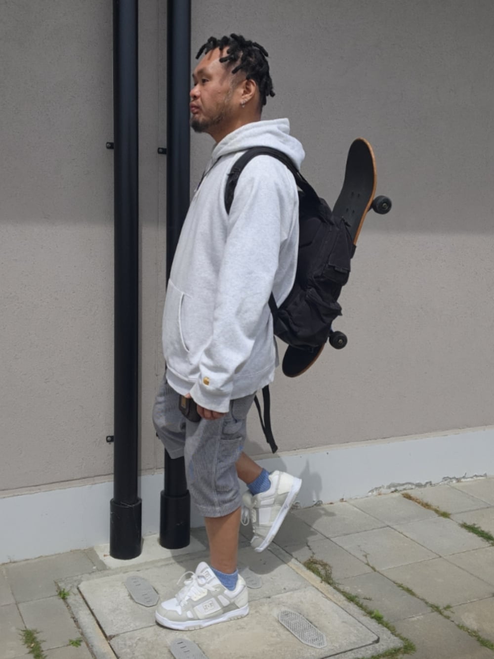 ホワイト系のチノパンツ、ホワイト系のスニーカー、グレー系のパーカーを着用したメンズの春コーディネートの3枚目の写真