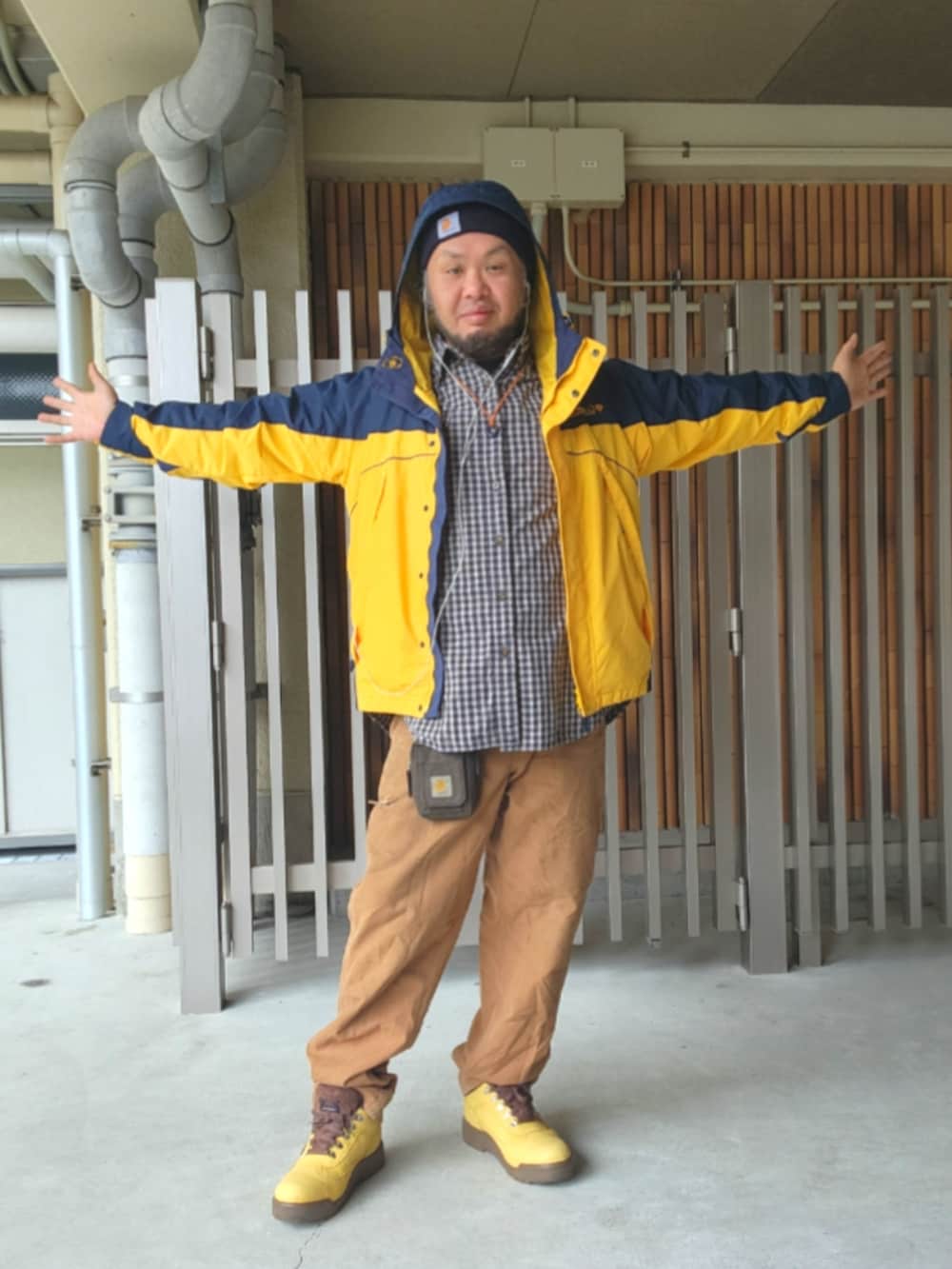 ゴールド系のブーツ、ブラウン系のカーゴパンツ、イエロー系のナイロンジャケットを着用したメンズの春コーディネートの4枚目の写真