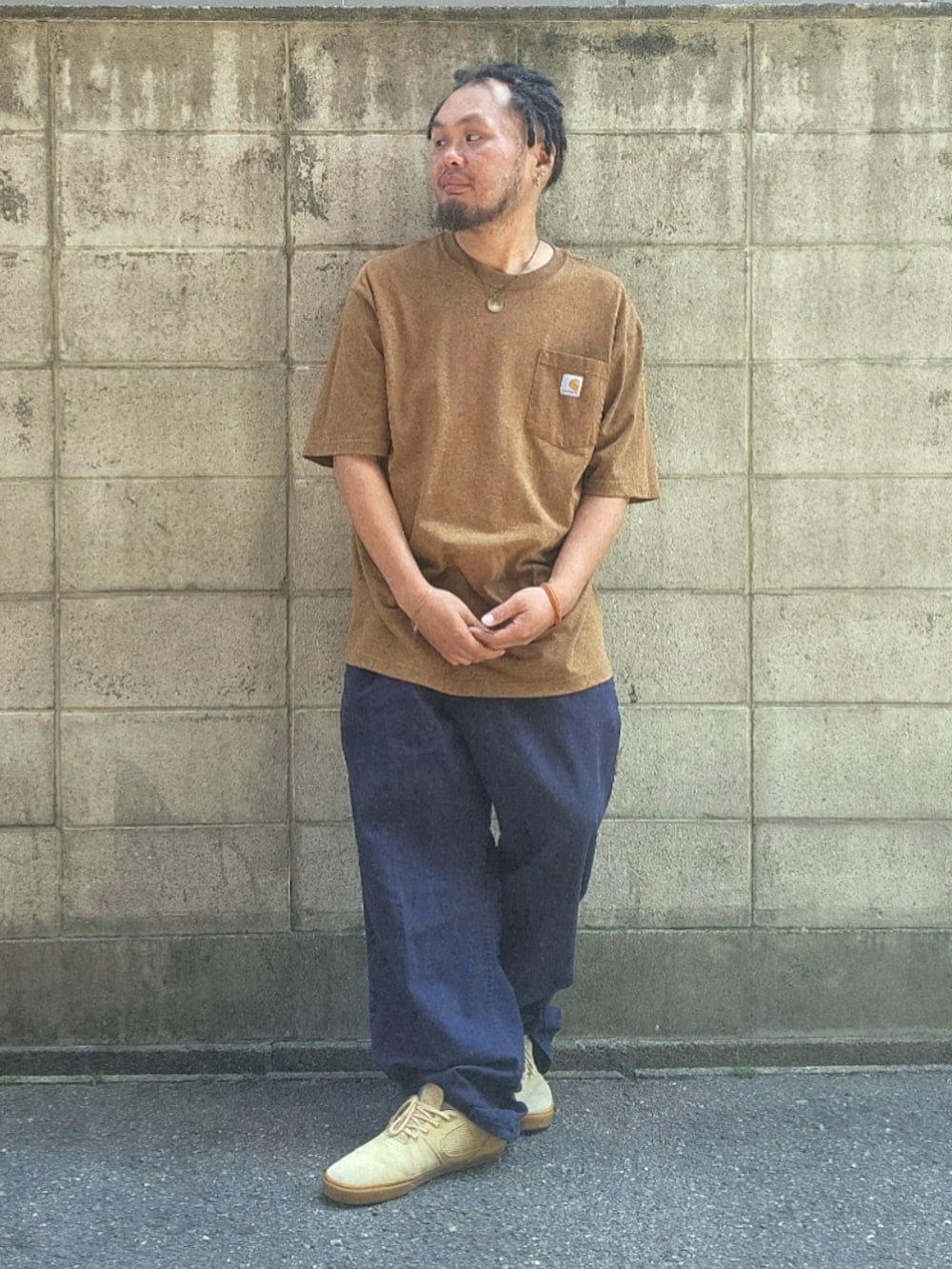 ブルー系のパンツ、ベージュ系のスニーカー、ブラウン系のTシャツ/カットソーを着用したメンズの春コーディネートの2枚目の写真