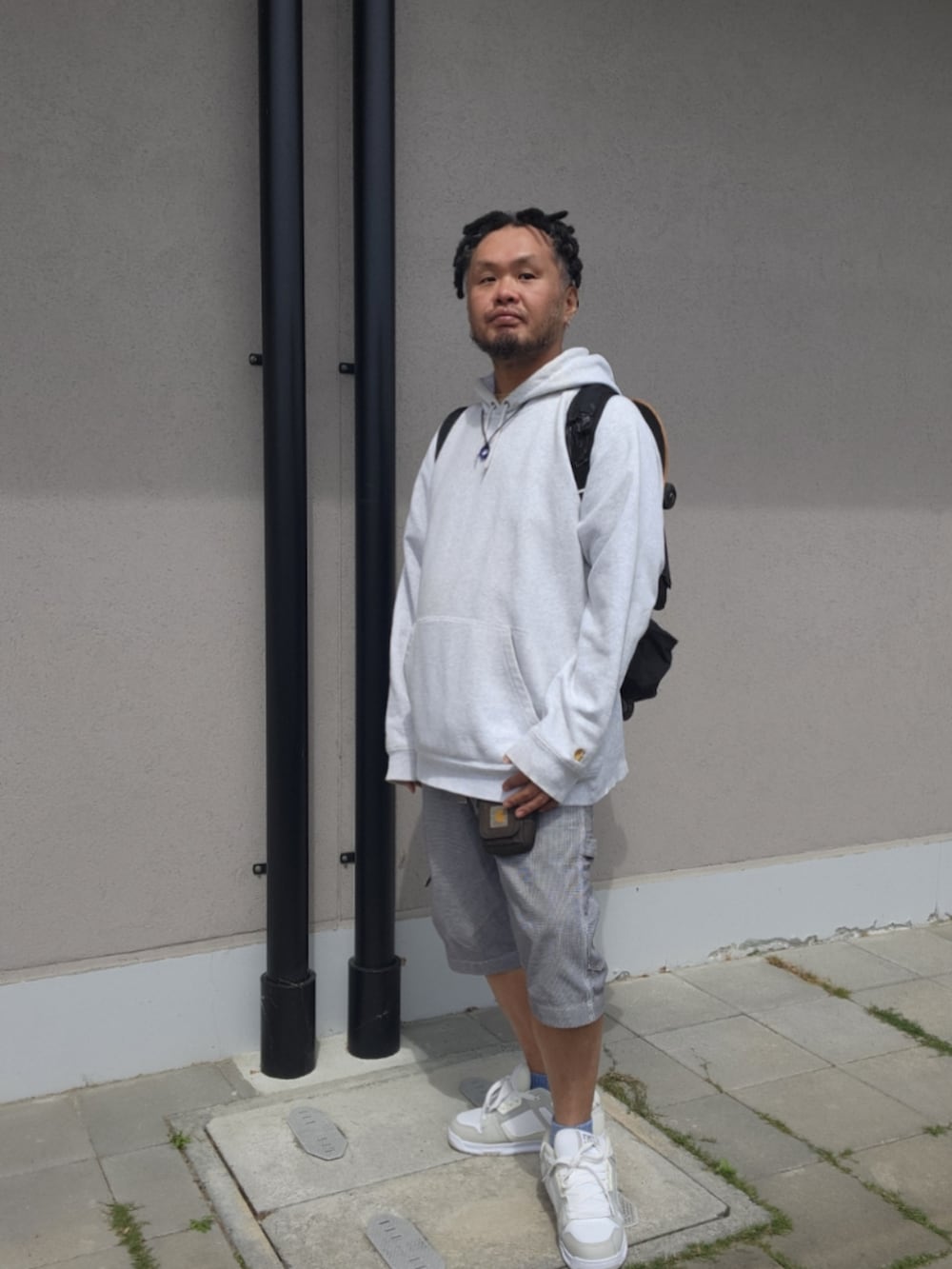 ホワイト系のチノパンツ、ホワイト系のスニーカー、グレー系のパーカーを着用したメンズの春コーディネートの5枚目の写真