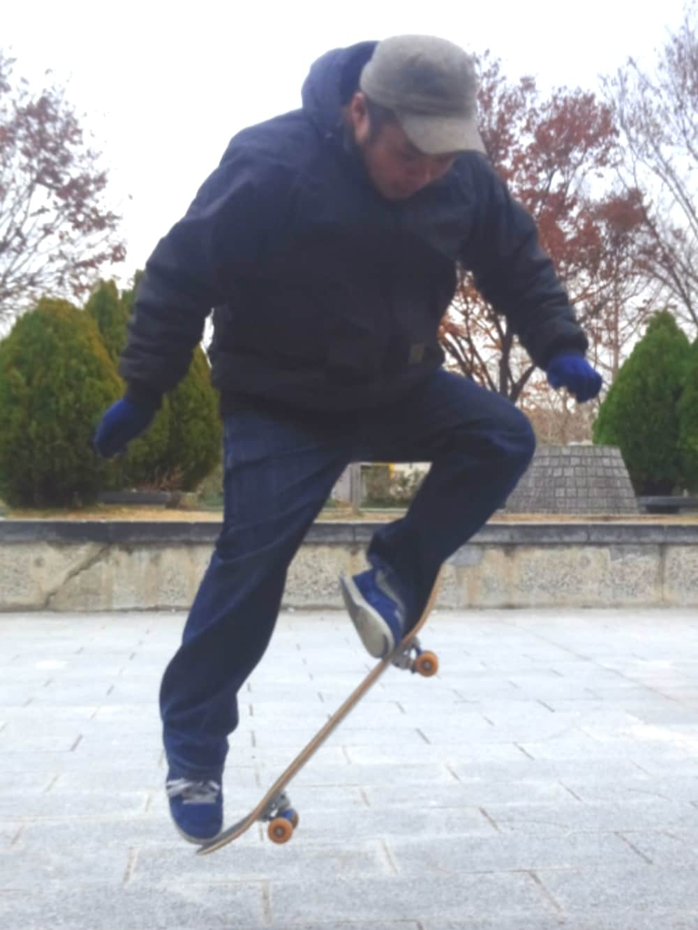 ブラック系のナイロンジャケット、ブルー系のデニムパンツ、ブルー系のスニーカーを着用したメンズの春コーディネートの2枚目の写真