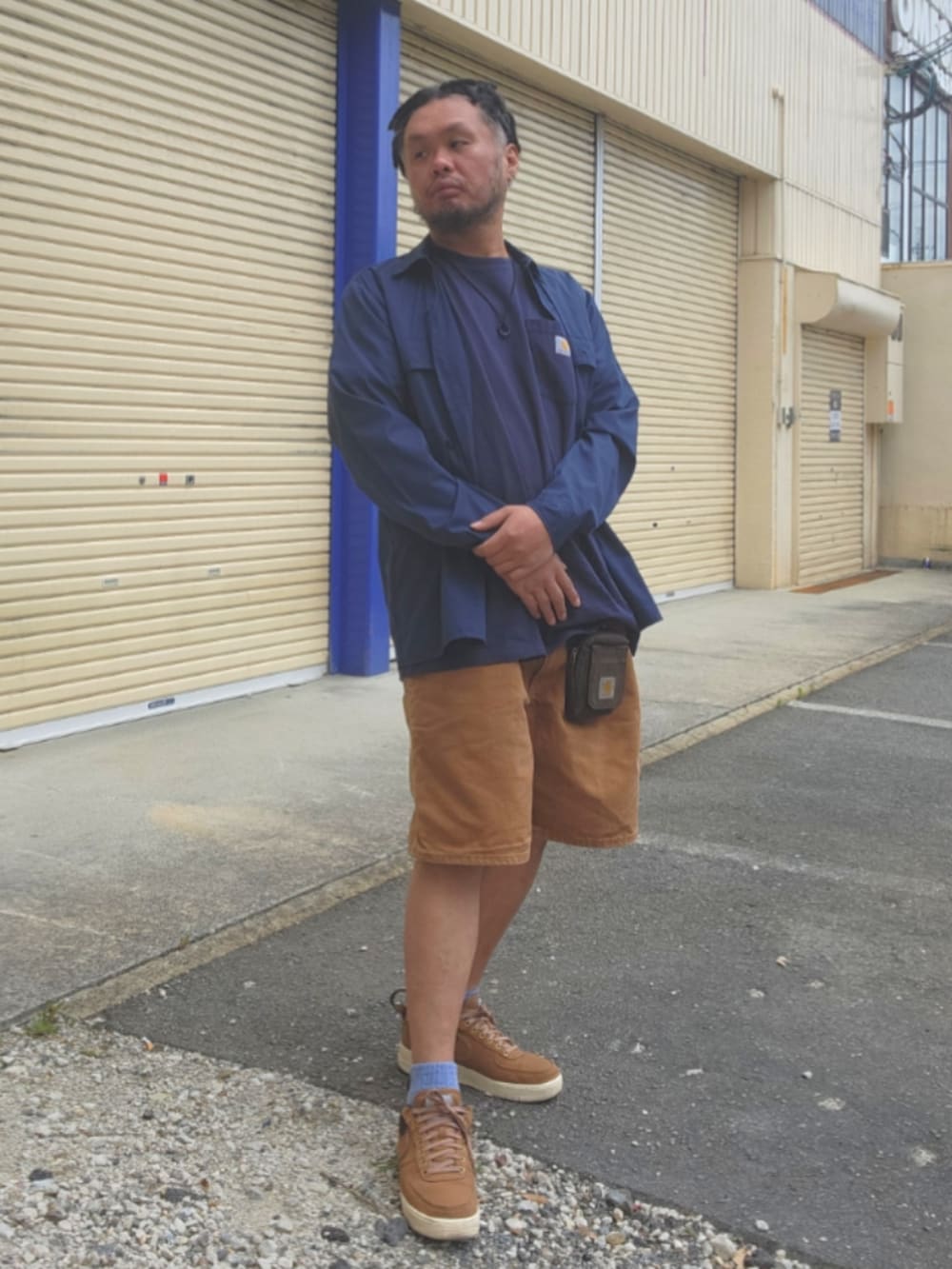 ブラウン系のスニーカー、ブラウン系のカーゴパンツ、ブルー系のシャツ/ブラウスを着用したメンズの春コーディネートの3枚目の写真