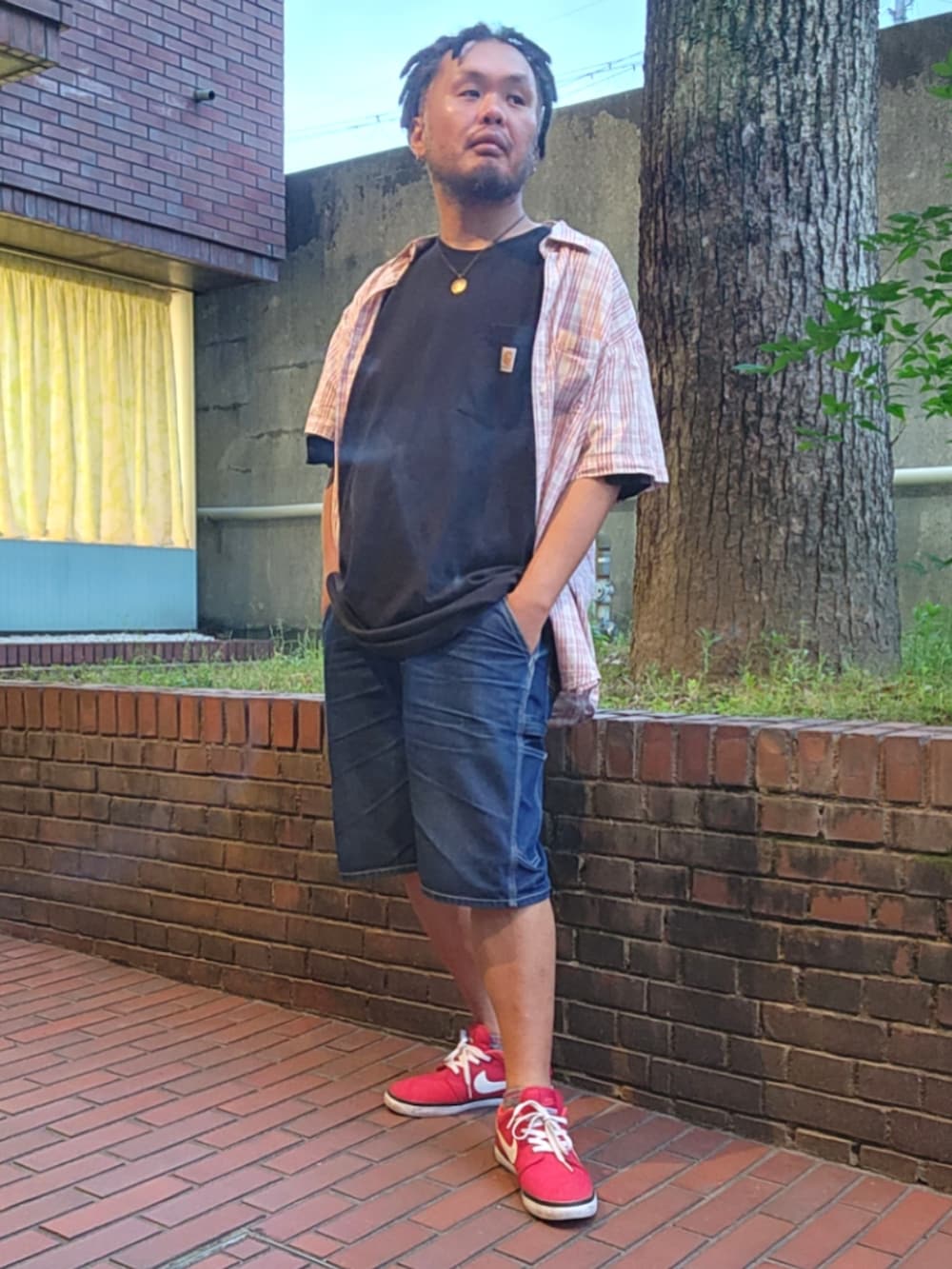 レッド系のスニーカー、ブルー系のデニムパンツ、ブラック系のTシャツ/カットソーを着用したメンズの春コーディネートの2枚目の写真