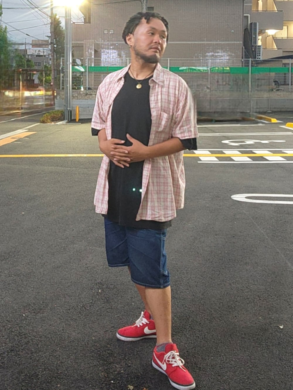 レッド系のスニーカー、ブルー系のデニムパンツ、ブラック系のTシャツ/カットソーを着用したメンズの春コーディネートの5枚目の写真