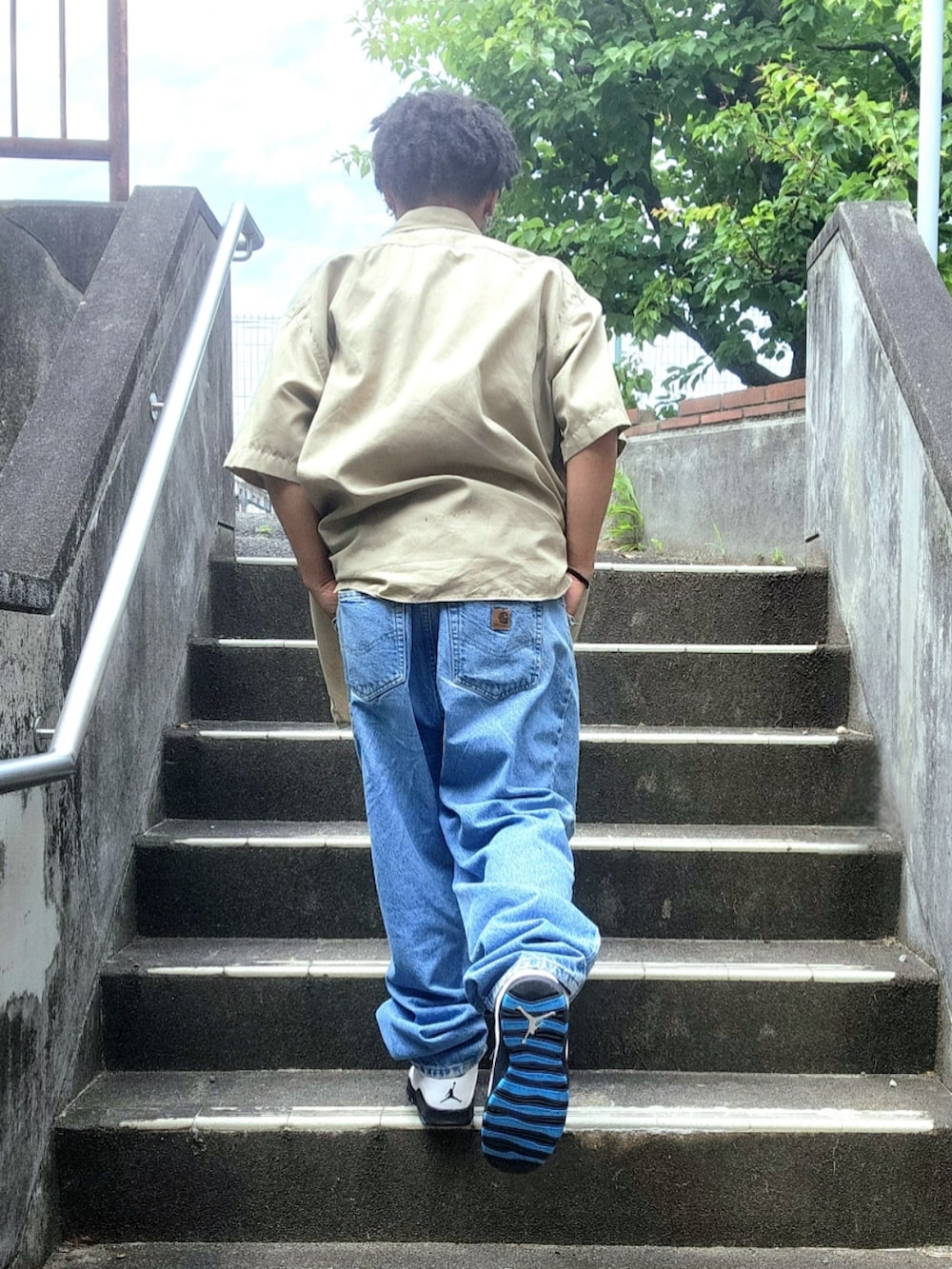 ブルー系のスニーカー、ブルー系のデニムパンツ、ホワイト系のTシャツ/カットソーを着用したメンズの夏コーディネートの5枚目の写真