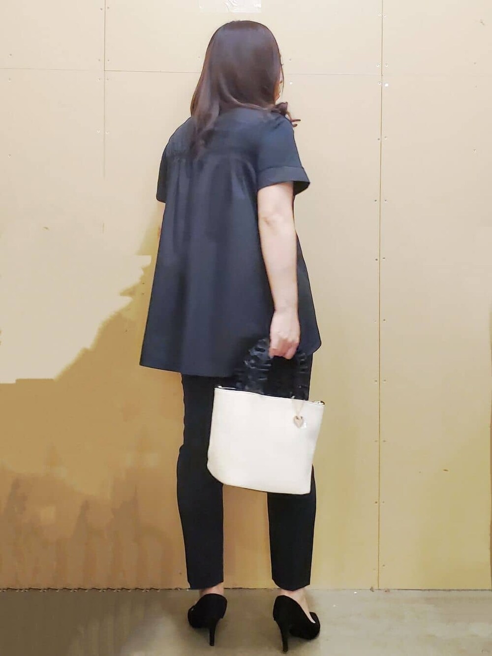 ブラック系のチュニック、ブラック系のその他パンツ、ホワイト系のトートバッグを着用したレディースの夏コーディネートの3枚目の写真