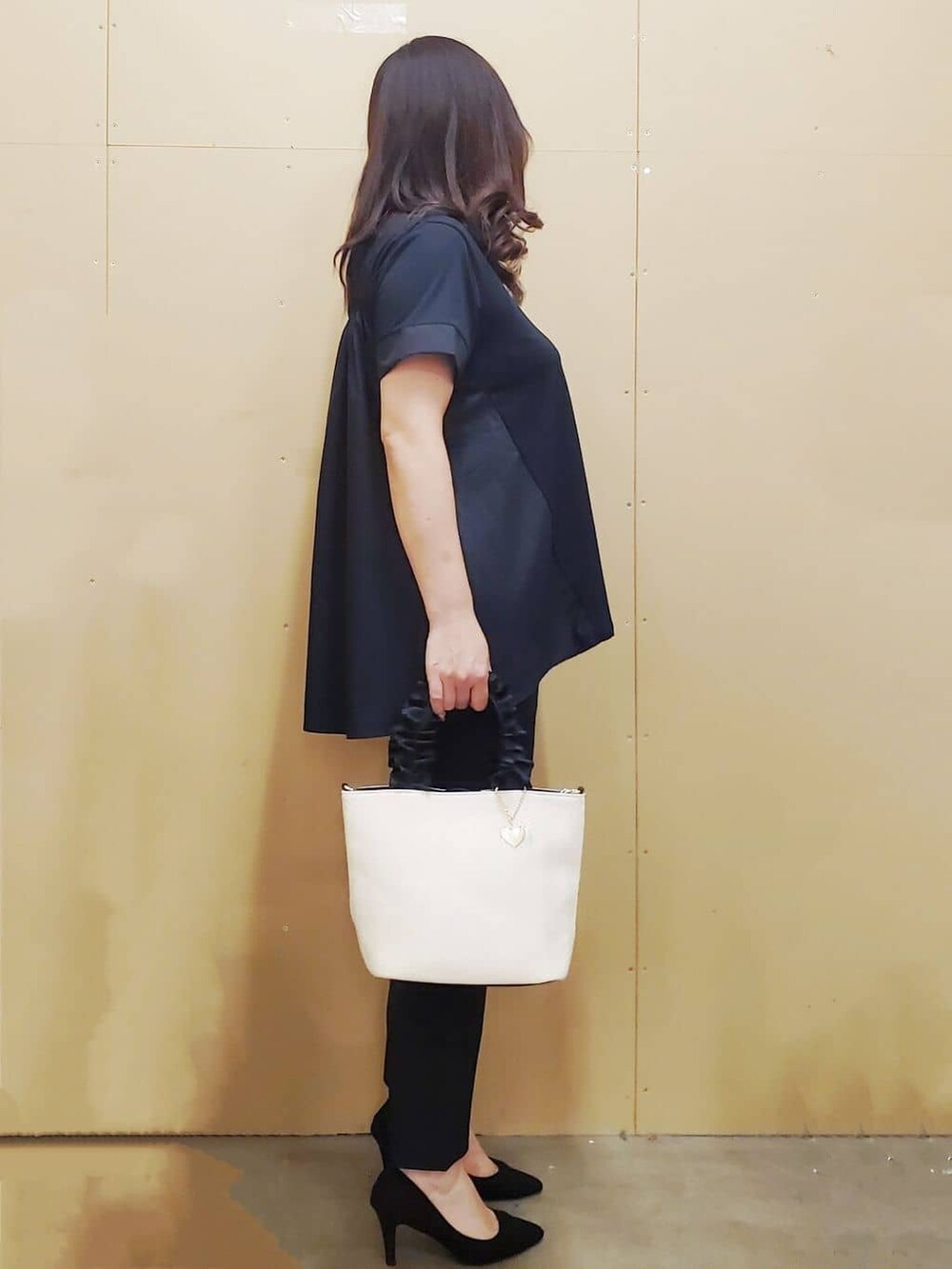 ブラック系のチュニック、ブラック系のその他パンツ、ホワイト系のトートバッグを着用したレディースの夏コーディネートの2枚目の写真