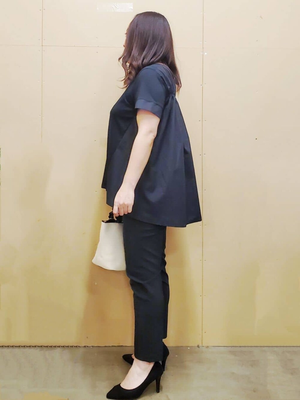 ブラック系のチュニック、ブラック系のその他パンツ、ホワイト系のトートバッグを着用したレディースの夏コーディネートの4枚目の写真