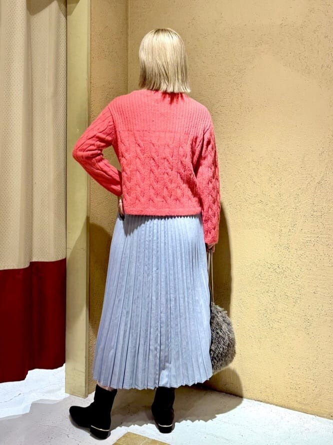 レッド系のニット/セーター、グレー系のスカート、ブラウン系のショルダーバッグを着用したレディースの冬コーディネートの6枚目の写真