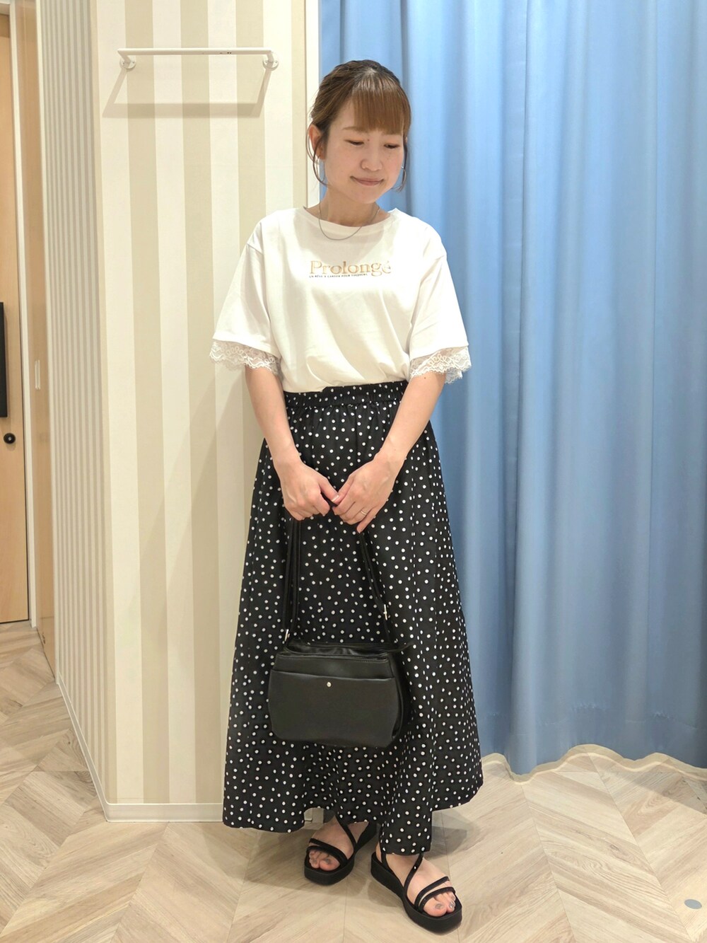 ホワイト系のTシャツ/カットソー、ブラック系のスカート、ブラック系のサンダルを着用したレディースの夏コーディネートの2枚目の写真