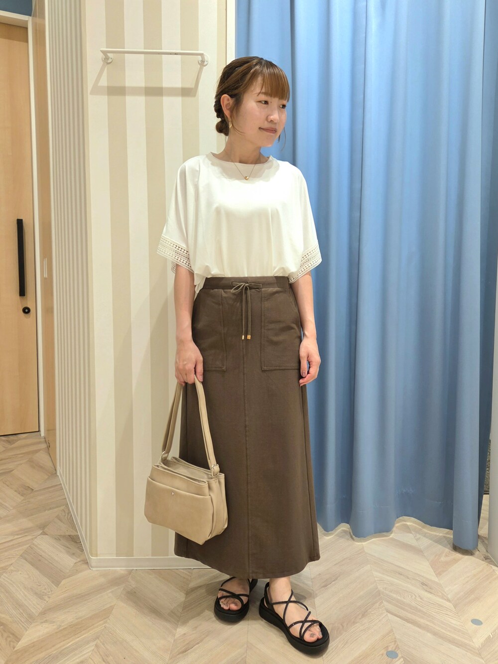 ホワイト系のTシャツ/カットソー、ブラウン系のスカートを着用したレディースの夏コーディネートの5枚目の写真