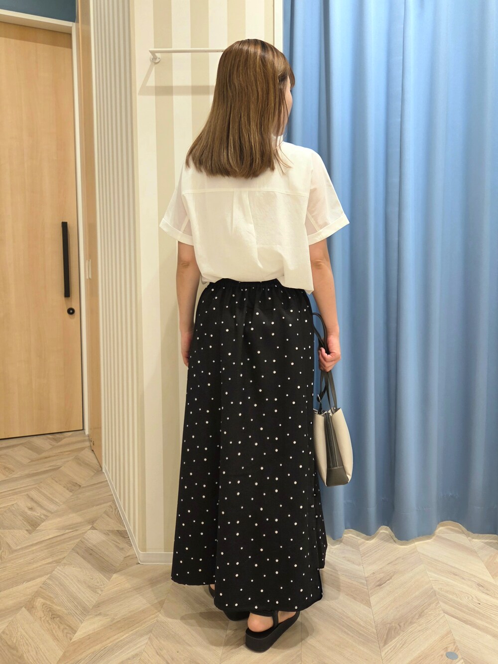 ホワイト系のシャツ/ブラウス、ホワイト系のタンクトップ、ブラック系のスカートを着用したレディースの夏コーディネートの3枚目の写真