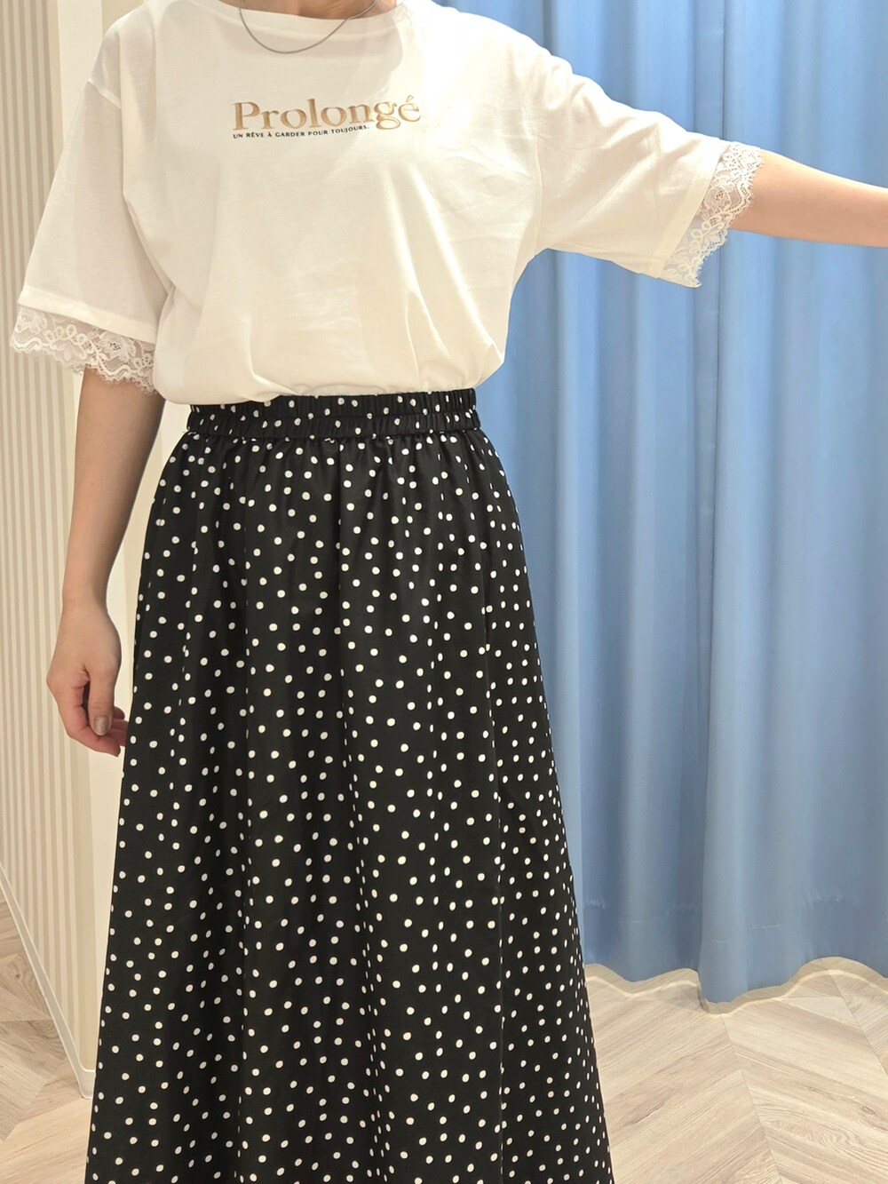 ホワイト系のTシャツ/カットソー、ブラック系のスカート、ブラック系のサンダルを着用したレディースの夏コーディネートの6枚目の写真