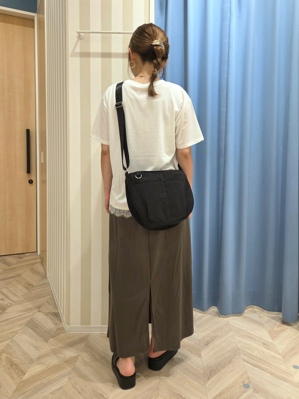 ホワイト系のTシャツ/カットソー、グリーン系のスカート、ブラック系のサンダルを着用したレディースの夏コーディネートの3枚目の写真