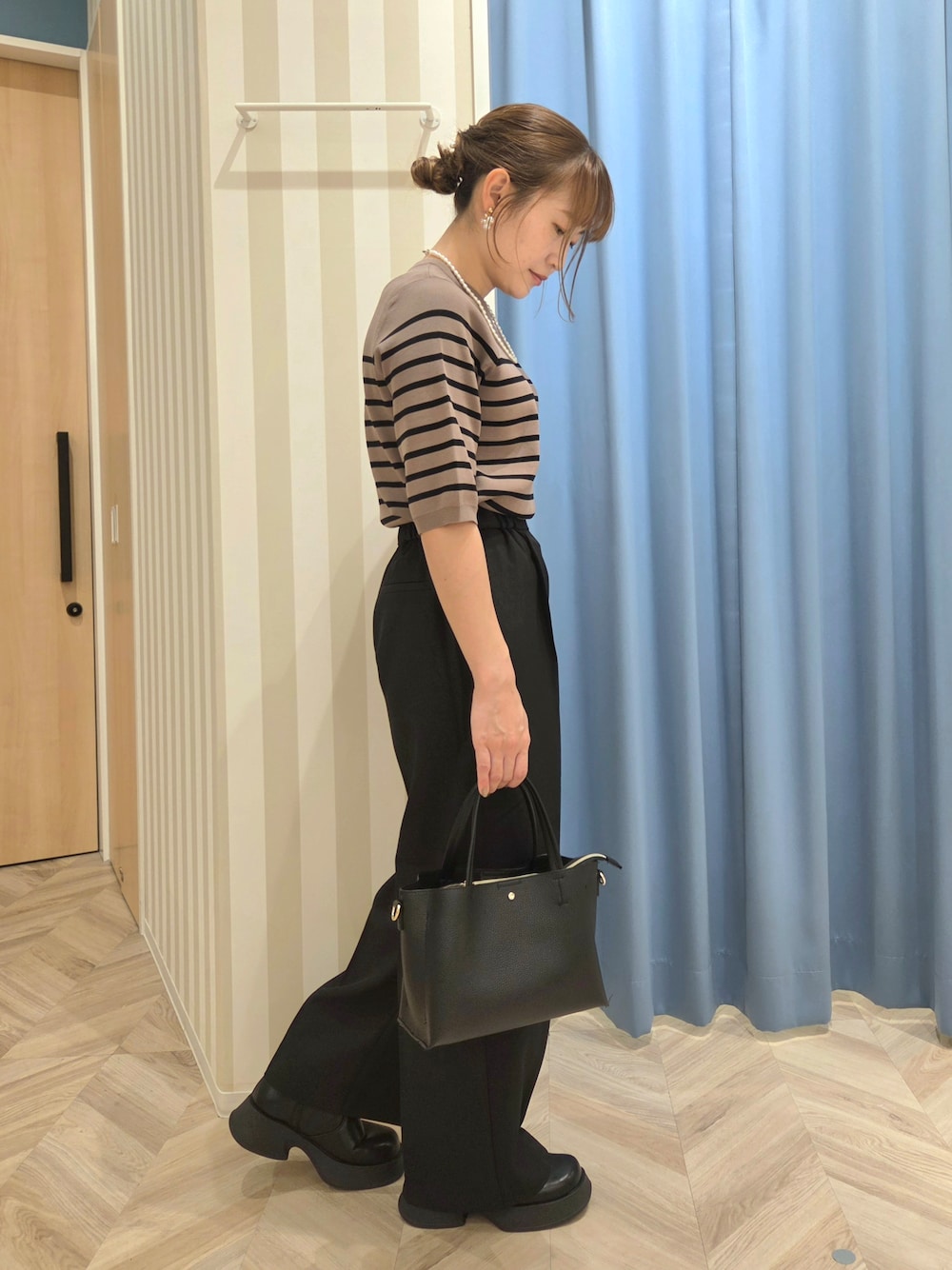 ブラック系のテーラードジャケット、ブラウン系のニット/セーター、ブラック系のその他パンツを着用したレディースの秋コーディネートの8枚目の写真