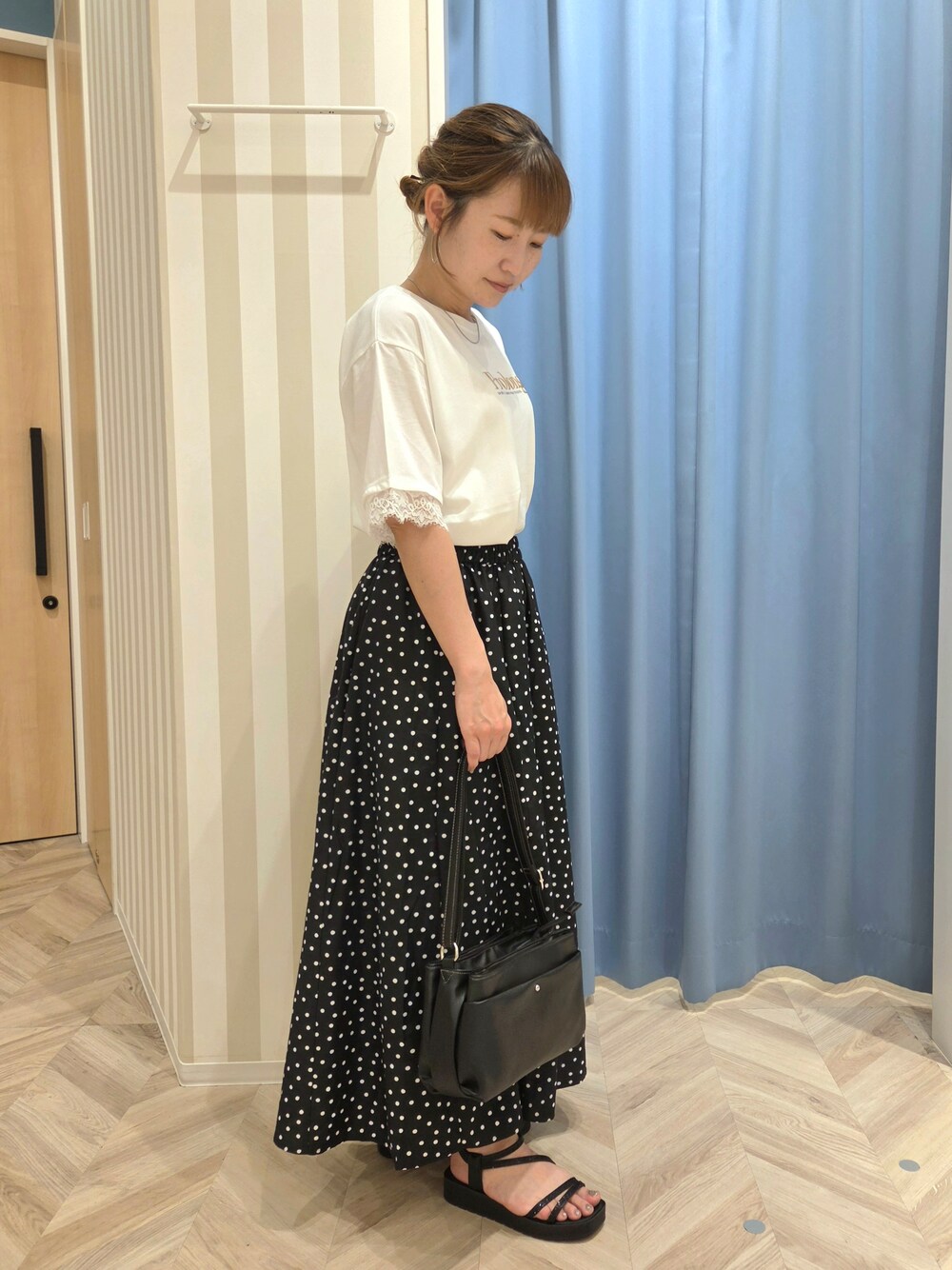 ホワイト系のTシャツ/カットソー、ブラック系のスカート、ブラック系のサンダルを着用したレディースの夏コーディネートの3枚目の写真