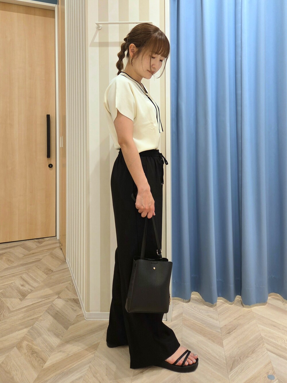 ホワイト系のニット/セーター、ブラック系のその他パンツ、ブラック系のサンダルを着用したレディースの夏コーディネートの2枚目の写真