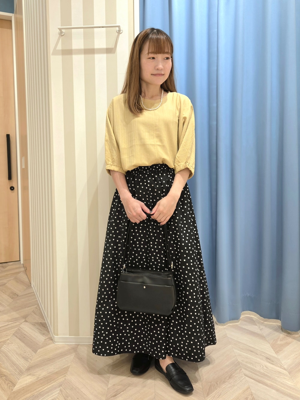 イエロー系のシャツ/ブラウス、ブラック系のスカート、ブラック系のパンプスを着用したレディースの秋コーディネートの2枚目の写真