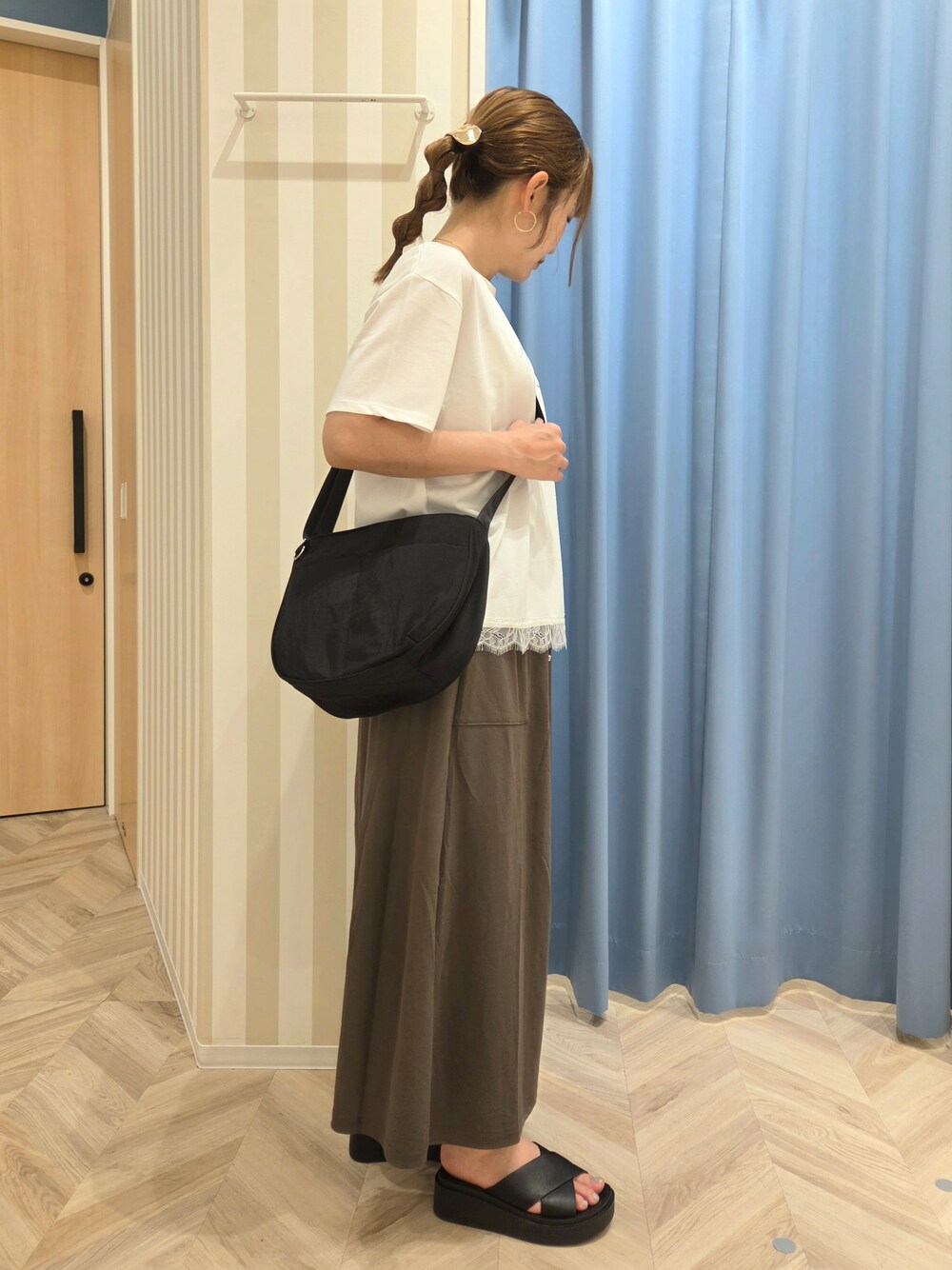 ホワイト系のTシャツ/カットソー、グリーン系のスカート、ブラック系のサンダルを着用したレディースの夏コーディネートの2枚目の写真