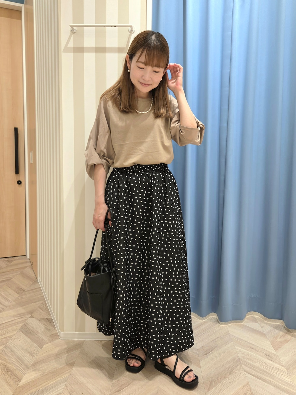ブラウン系のTシャツ/カットソー、ブラック系のスカート、ブラック系のサンダルを着用したレディースの夏コーディネートの2枚目の写真
