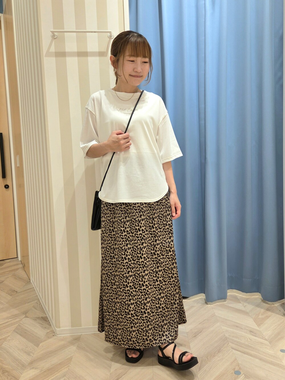 ホワイト系のTシャツ/カットソー、ブラウン系のスカート、ブラック系のサンダルを着用したレディースの夏コーディネートの4枚目の写真