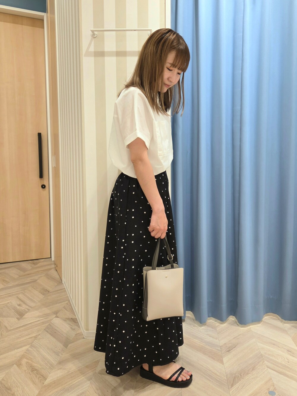 ホワイト系のシャツ/ブラウス、ホワイト系のタンクトップ、ブラック系のスカートを着用したレディースの夏コーディネートの2枚目の写真