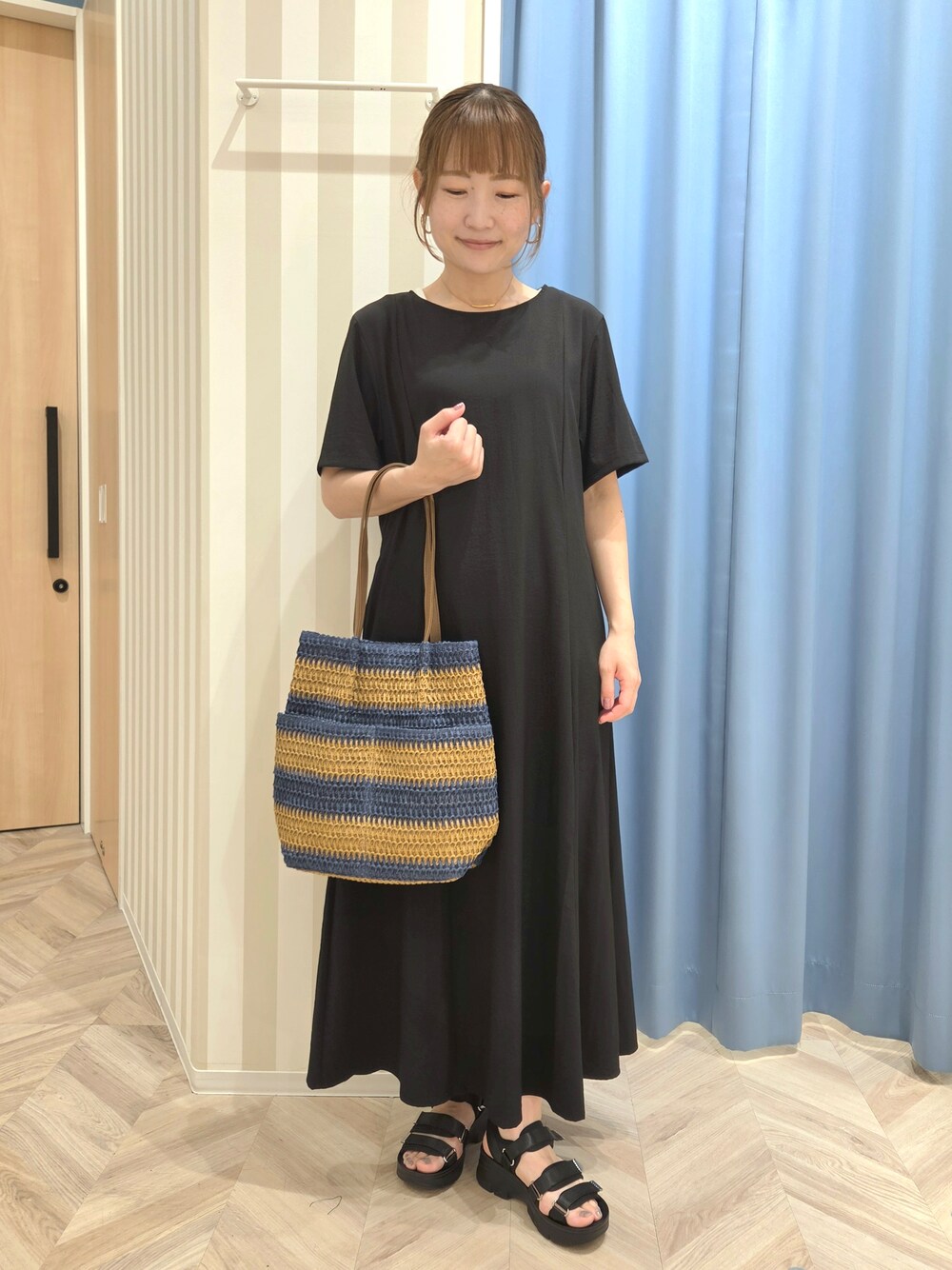 ホワイト系のカーディガン/ボレロ、ブラック系のワンピース、ブラック系のサンダルを着用したレディースの夏コーディネートの2枚目の写真