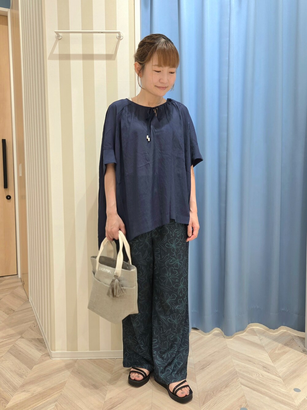 ブルー系のその他パンツ、ブラック系のサンダル、グレー系のトートバッグを着用したレディースの夏コーディネートの2枚目の写真