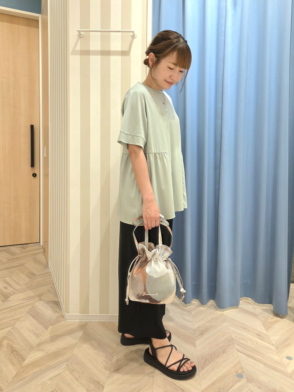 グリーン系のTシャツ/カットソー、ベージュ系のショルダーバッグを着用したレディースの夏コーディネートの2枚目の写真