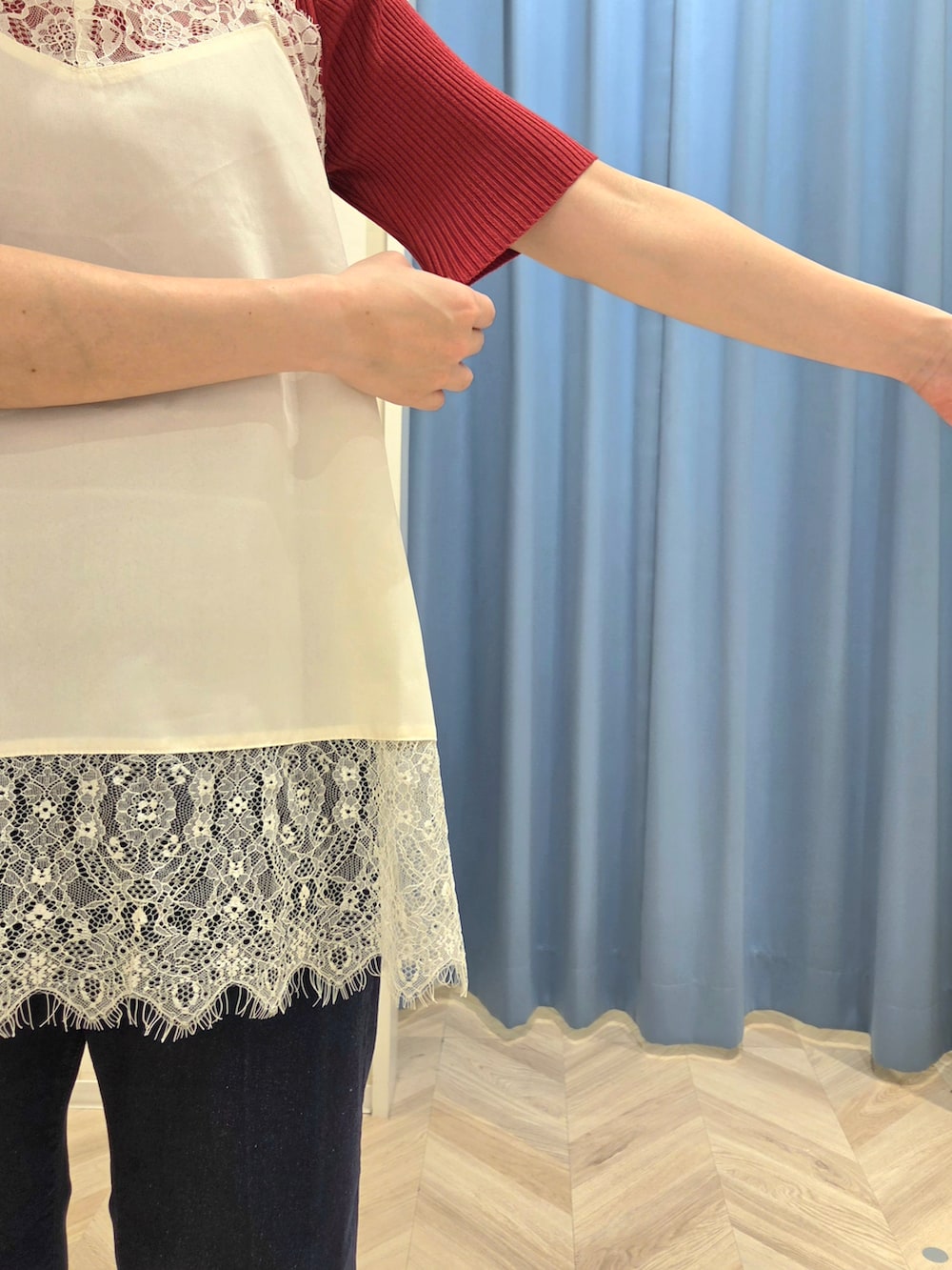 レッド系のニット/セーター、ホワイト系のTシャツ/カットソー、ブルー系のデニムパンツを着用したレディースの秋コーディネートの6枚目の写真