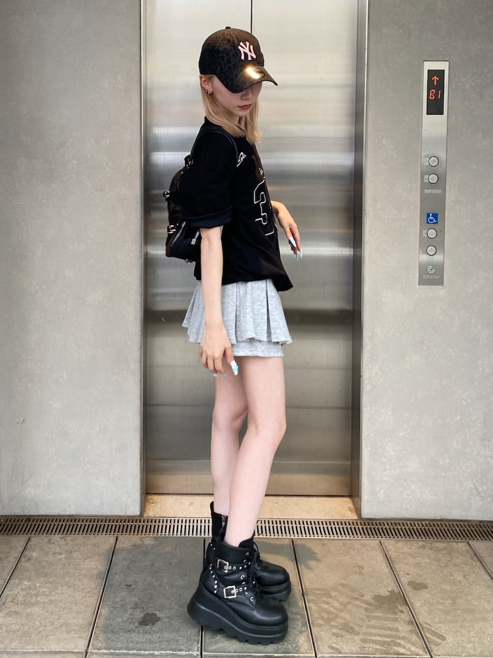 ブラック系のTシャツ/カットソー、グレー系のスカート、ブラック系のショルダーバッグを着用したレディースの夏コーディネートの2枚目の写真