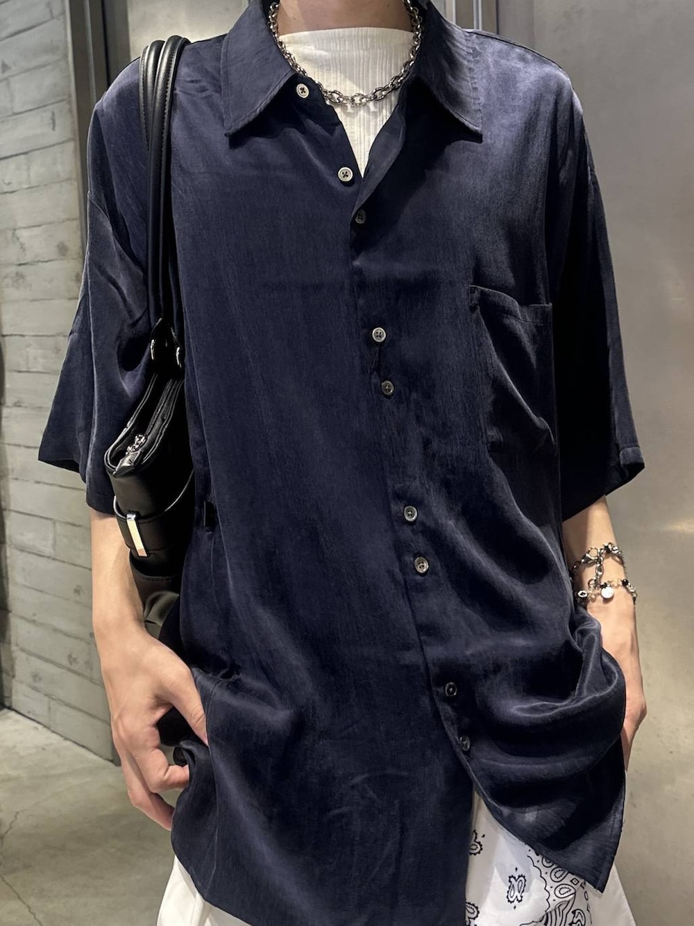 ホワイト系のTシャツ/カットソー、ブラック系のスニーカー、ホワイト系のスラックスを着用したメンズの夏コーディネートの4枚目の写真