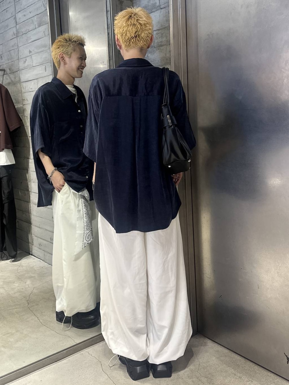 ホワイト系のTシャツ/カットソー、ブラック系のスニーカー、ホワイト系のスラックスを着用したメンズの夏コーディネートの3枚目の写真